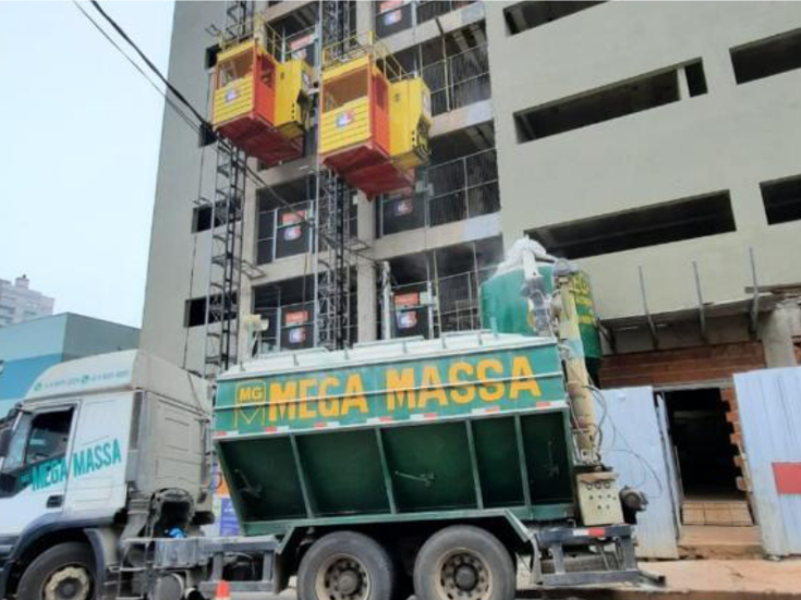 Caminhão silo Mega Massa em frente à obra