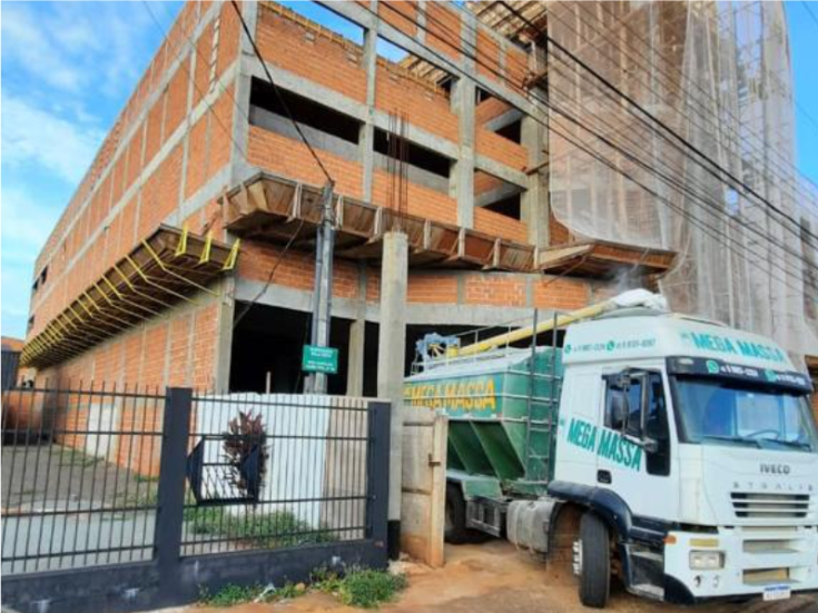 Caminhão Mega Massa em rua com silo ao fundo